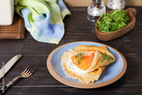 Pancake wrapped with cream cheese and smoked salmon. Crepe. photo