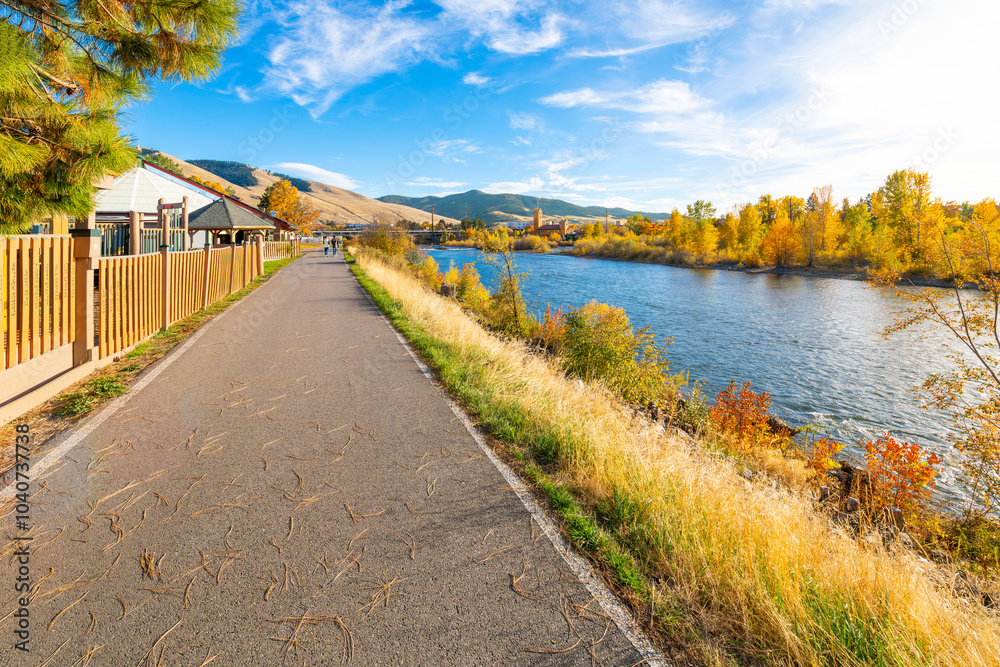 Fototapeta premium View from the Riverfront Trail along the Clark Fork River of the University District and tower of the Boone Crockett Club Natural History Museum in downtown Missoula, Montana.