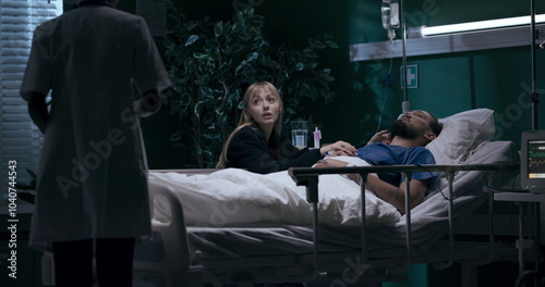 Family bonding in hospital room. Nurse enters to check on them during their playtime.