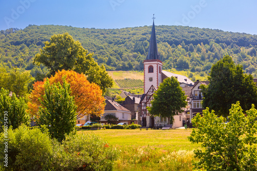 Traditional church in a German village surrounded by vineyards and green hills, Mosel photo