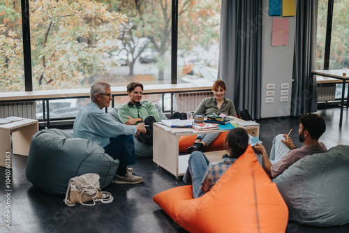 A professor engages with students in an informal classroom environment, fostering open dialogue and collaborative learning while sitting on bean bags. The scene highlights an interactive and modern
