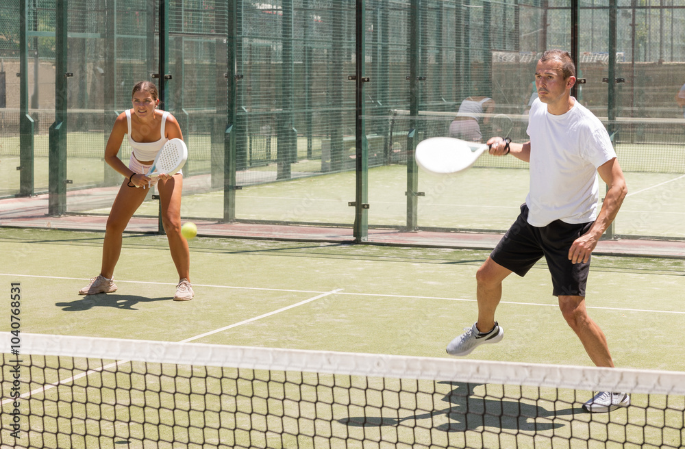 Obraz premium Sports woman and man playing padel on the tennis court