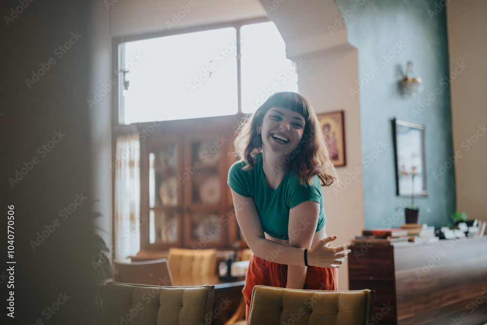 A cheerful woman in a casual outfit laughs joyfully in a warmly decorated living room, radiating happiness and positivity. A cheerful woman in a casual outfit laughs joyfully in a warmly decorated living room, radiating happiness and positivity.