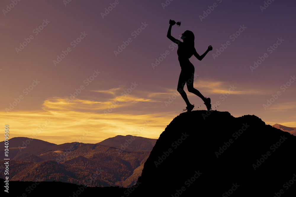 Winner with trophy cup in mountains at sunrise Winner with trophy cup in mountains at sunrise