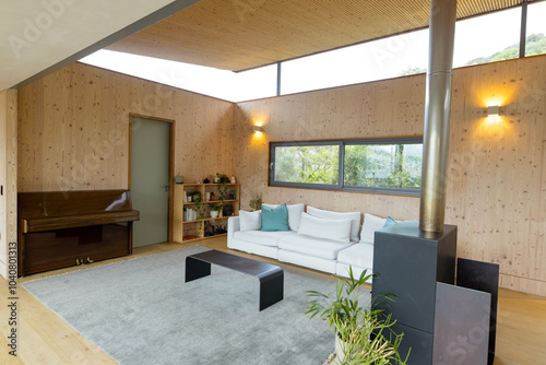 Modern living room with cozy sofa, piano, and large window view, at home
