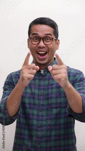A man cheering and pointing at the camera and give thumbs up