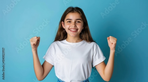 Triumphant Young Woman Celebrating Success in White T-Shirt and Blue Jeans photo