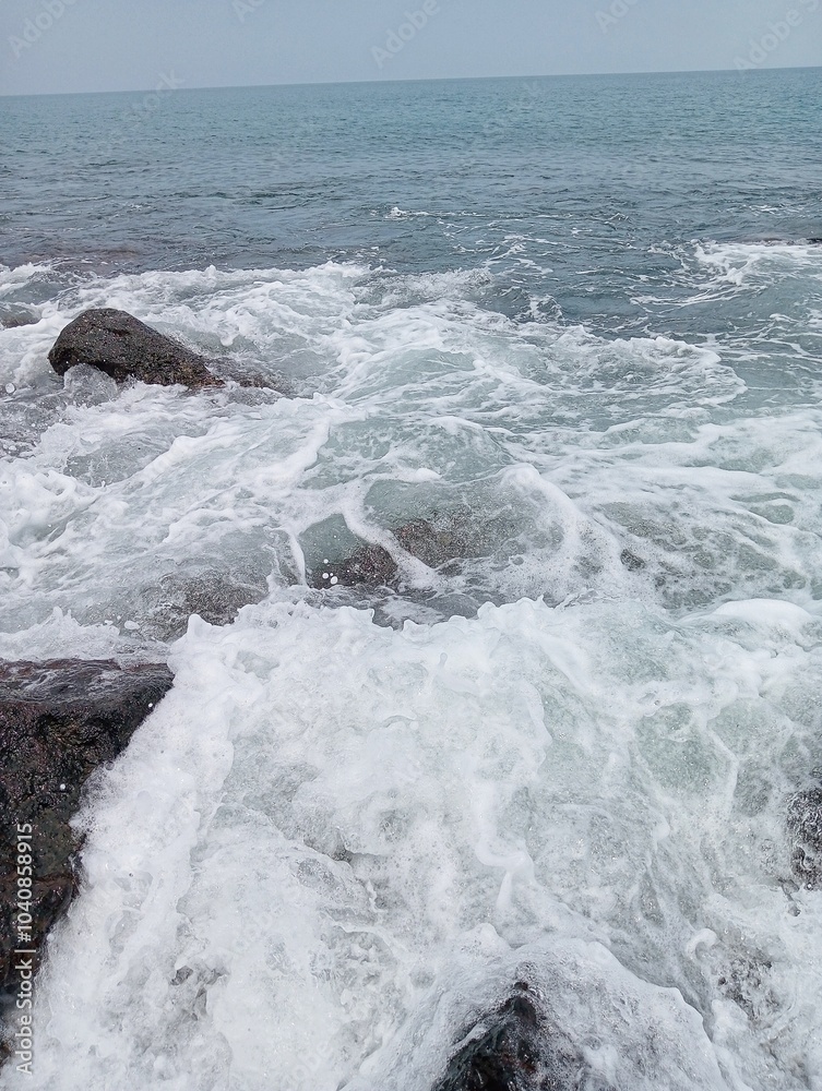 Waves crashing against the rocks on the shore Waves crashing against the rocks on the shore