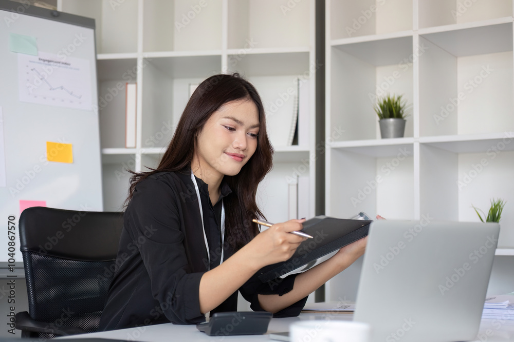Business Woman Working on Document on Laptop in Modern Office Setting with Shelves and Coffee Cup Business Woman Working on Document on Laptop in Modern Office Setting with Shelves and Coffee Cup