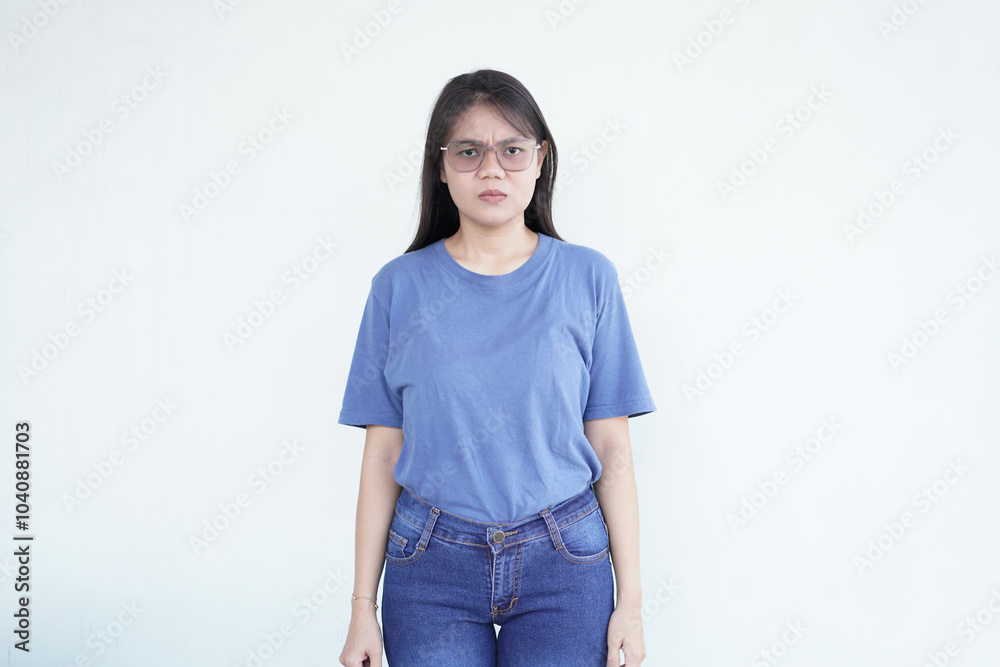 Beautiful Asian woman shows an angry gesture, her brows furrowed and fists clenched, expressing frustration against a white background Beautiful Asian woman shows an angry gesture, her brows furrowed and fists clenched, expressing frustration against a white background