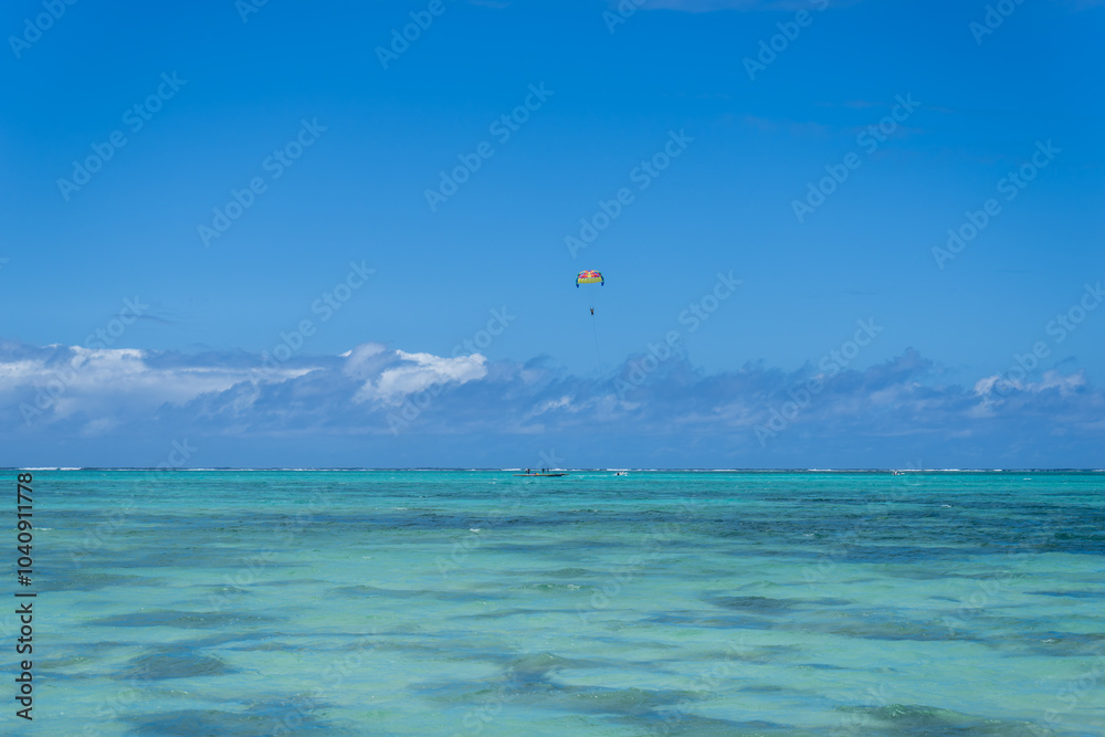 Visitors experience the thrill of paragliding in the beautiful lagoon of Ile Aux Cerfs, Mauritius. Visitors can glide effortlessly on the calm waters, surrounded by stunning scenery. Visitors experience the thrill of paragliding in the beautiful lagoon of Ile Aux Cerfs, Mauritius. Visitors can glide effortlessly on the calm waters, surrounded by stunning scenery.
