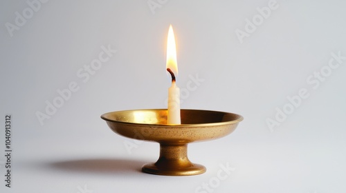 A single Hanukkah candle burning brightly in a simple brass holder, isolated against a clean white background, creating a peaceful scene