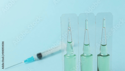 Medical Ampoules and Syringe on Blue Background for Healthcare Innovation and Safety