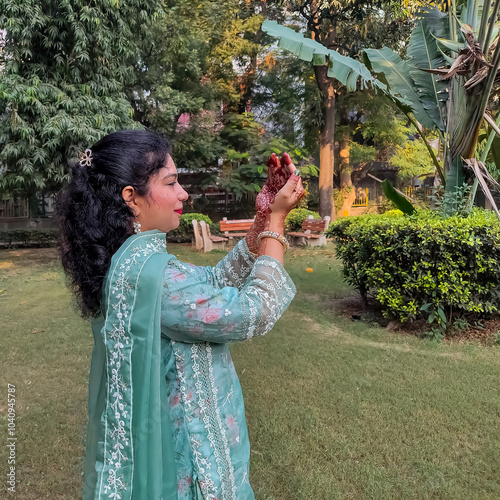 Beautiful woman dressed up as Indian tradition with henna mehndi design on her both hands to celebrate big festival of Karwa Chauth, Karwa Chauth celebrations by Indian woman for her husband photo