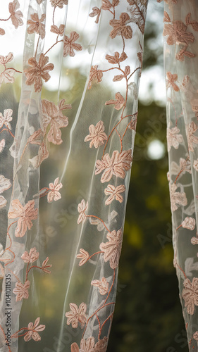 medium shot of sheer fabric curtain adorned with delicate floral embroidery, creating soft and elegant atmosphere. light filters through, enhancing beauty of design