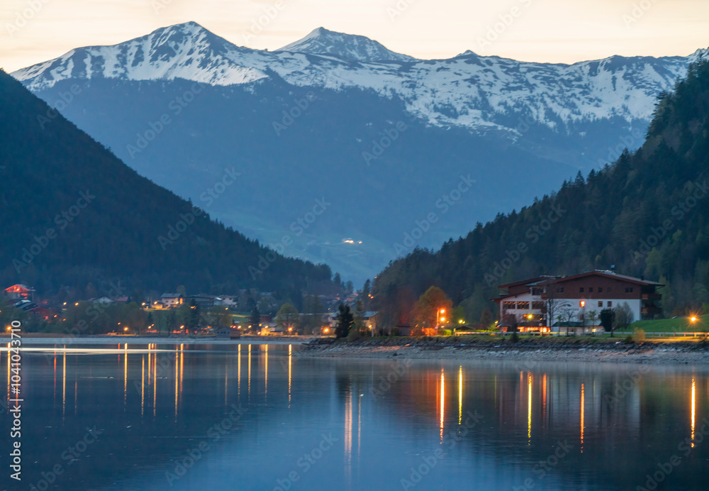 Early morning at the Achensee Tirol lake which is flat and quite and this cause a beautiful reflection of the water in a panoramic style