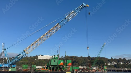 Boom arm of large construction crane against clear blue sky, copy space photo