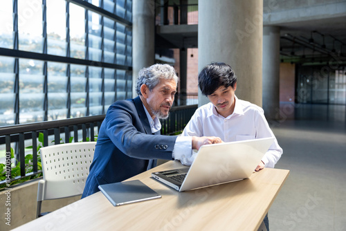 Asian senior professor is giving advice  to the college student on the research thesis while sitting in the university faculty for education, academic and business concept