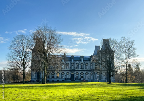 Bilde på lerret Historic mansion surrounded by lush green lawn and trees under a clear blue sky