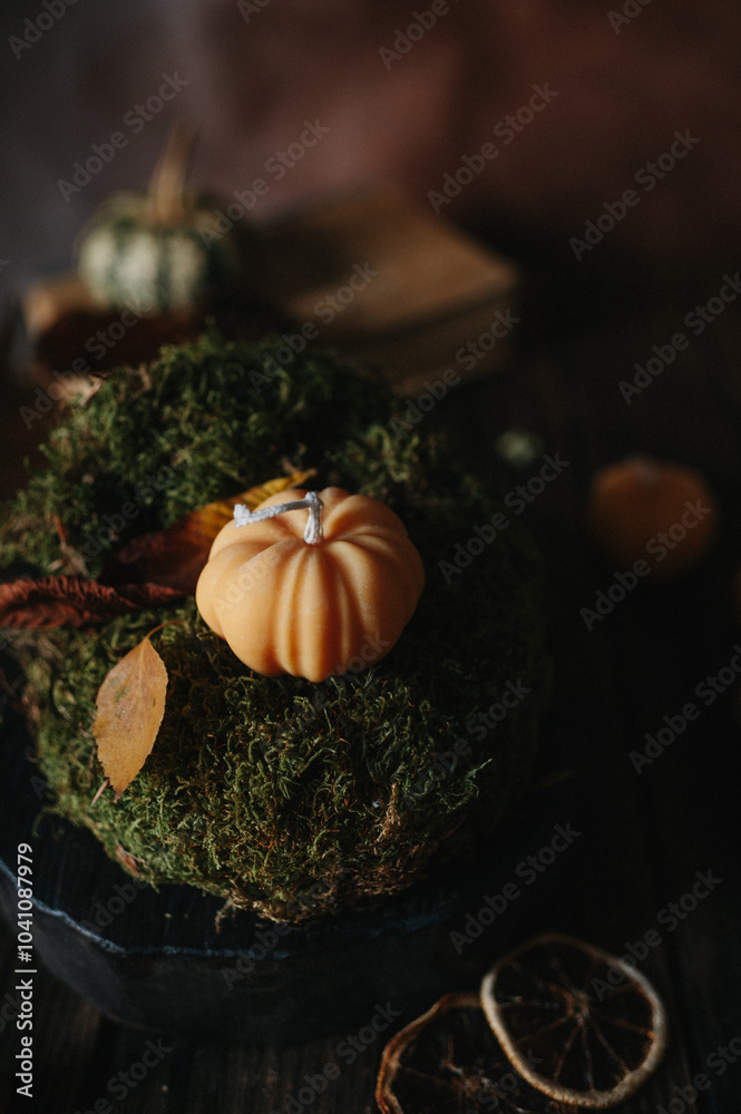 Handmade wax candle in the shape of pumpkins on a dark background Handmade wax candle in the shape of pumpkins on a dark background