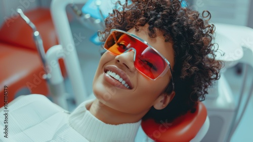 A woman in stylish glasses beams with confidence at the dentist, showing off a bright, healthy smile in a vibrant dental office. photo