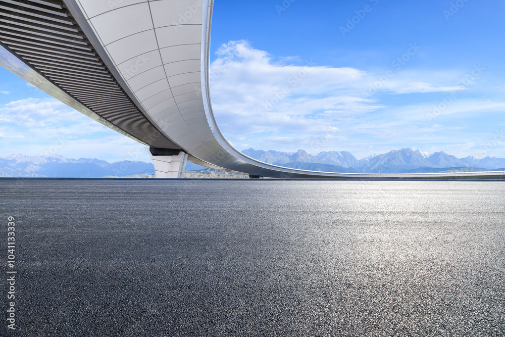 Asphalt road and bridge with mountain nature landscape under blue sky. Road trip.