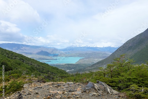 Scenic mountainous landscape with blue lake and green forest.