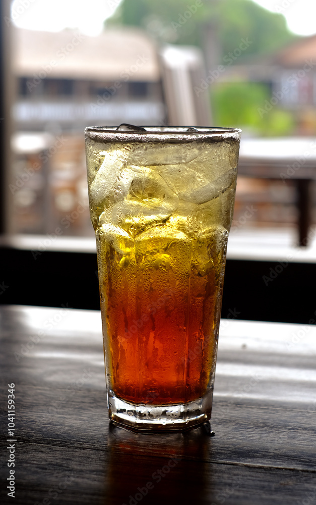 A glass of iced tea on a table with a bokeh background A glass of iced tea on a table with a bokeh background