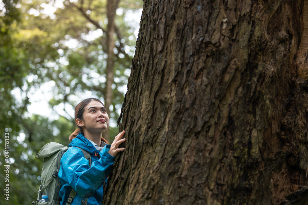 Young Woman Exploring Forest, Wearing Blue Jacket, Touching Large Tree Trunk, Connecting with Nature, Enjoying Tranquil Outdoor Experience, Appreciating Wildlife and Environment, Peaceful Nature Walk Young Woman Exploring Forest, Wearing Blue Jacket, Touching Large Tree Trunk, Connecting with Nature, Enjoying Tranquil Outdoor Experience, Appreciating Wildlife and Environment, Peaceful Nature Walk