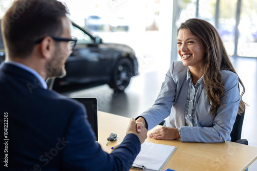 Car, dealership or documents with salesman and customer in showroom for conversation, deal or offer. Contract, finance or insurance with agent and woman in discussion for vehicle purchase