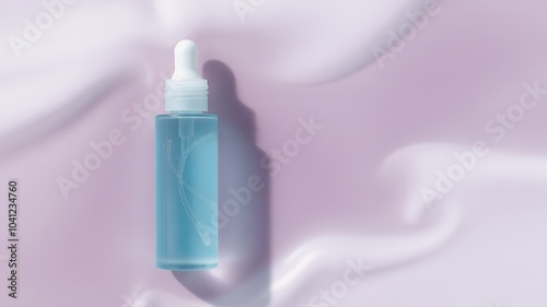 A dropper bottle of blue serum on a white silky background.