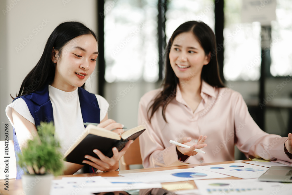 Asian business woman talking, working on graph documents Asian business woman talking, working on graph documents