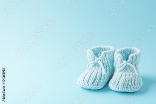 Close up of wool baby booties. Pregnancy concept, Pairs of baby shoes on a light blue background. Gender neutral baby garment and accessories. Organic newborn bootie, fashion, branding, small business