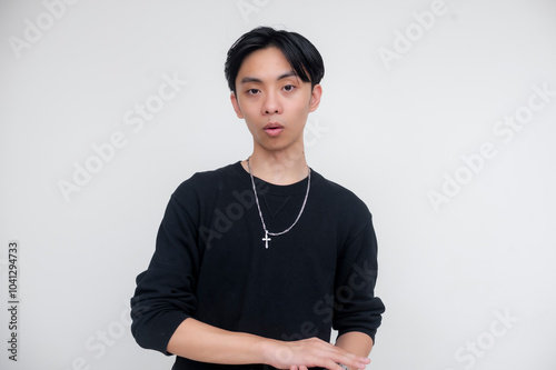 Фотография Young asian man clapping absentmindedly, expressing boredom and disinterest, isolated against a white background wearing a black shirt and a silver chain