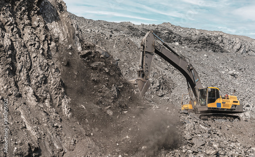 Large quarry dump excavator. Big yellow mining excavator at work site. Loading coal into body truck. Mining digger, mining machinery to loading rock. Production useful minerals photo