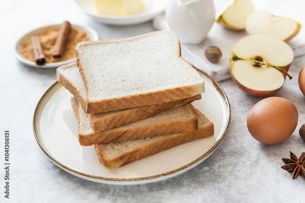 Sliced toast bread on a plate for breakfast, making of sweet French toast dessert with apples Sliced toast bread on a plate for breakfast, making of sweet French toast dessert with apples