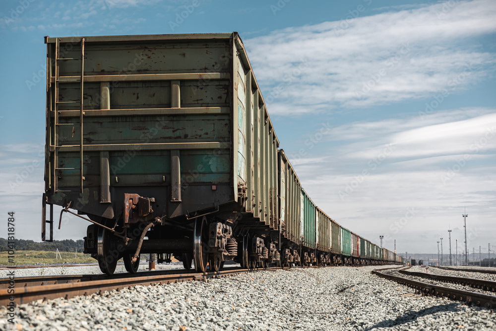 Fototapeta premium Panorama railroad tracks with wagons and railway transport. View to railway station with railroad tracks with wagons. Loading railway cars. Railway wagons standing at the station waiting for loading