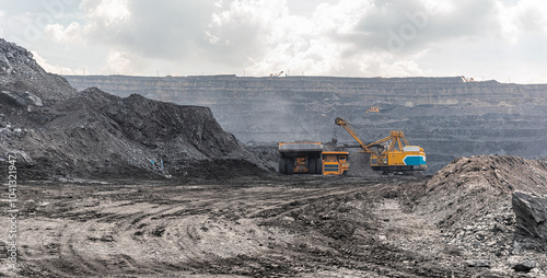 Panoramic view of coal mine. Open pit mine industry, big yellow mining truck for coal quarry. Open coal mining anthracite mining. Pit on coal mining by open way. Rock loading in trucks. Large truck