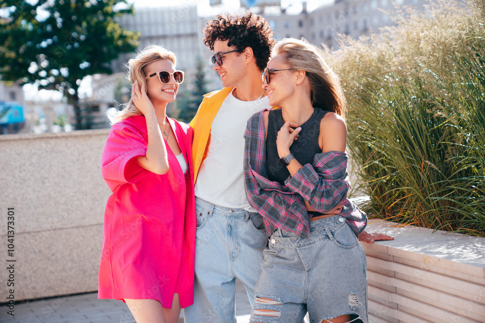 Group of young three stylish friends posing in the street. Fashion man and two cute female dressed in casual summer clothes. Smiling models having fun. Cheerful women and guy outdoors, sunglasses Group of young three stylish friends posing in the street. Fashion man and two cute female dressed in casual summer clothes. Smiling models having fun. Cheerful women and guy outdoors, sunglasses