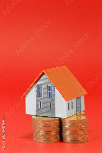 Property Tax on buildings - Property Real Estate concept with a small home model and euro coins group - Growth in property value concept with copy space photo