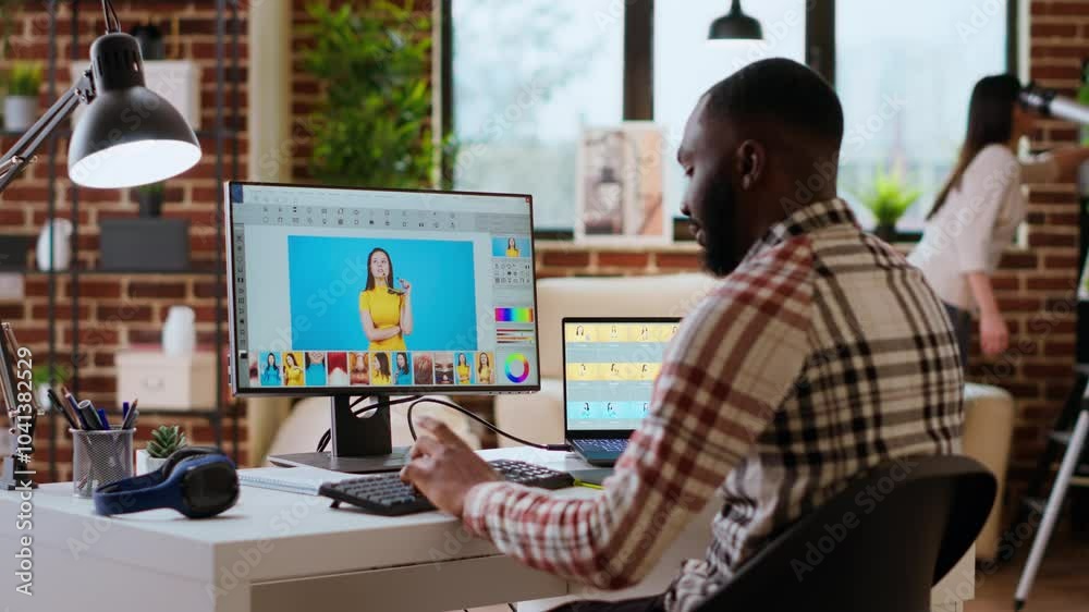 Freelance graphic designer editing photos on a modern computer setup in a remote office. Ideal workspace for a digital design professional, retouching digital pictures from home. Camera B.