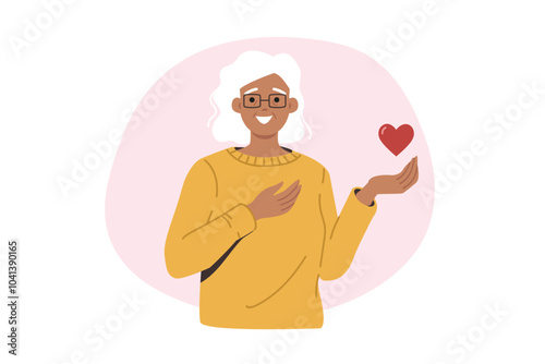 Kind elderly woman holds heart in hand and looks at screen smiling, calling for kindness and love. Elderly woman reminds of importance of donation to increase life span of old people.