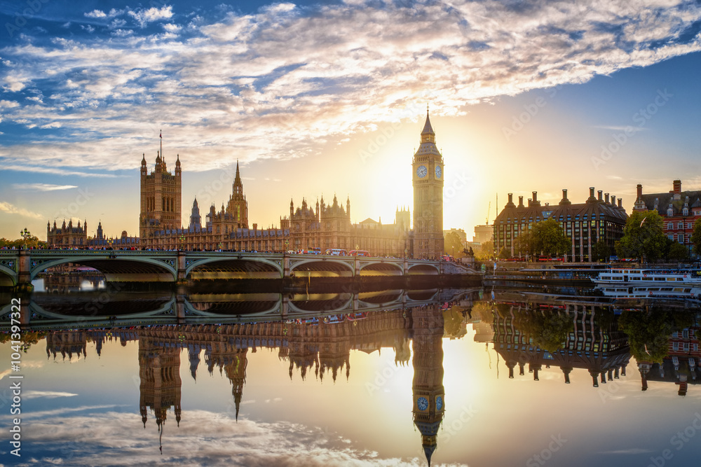 Fototapeta premium The Westminster Palace and Big Ben clocktower in London, England, during a beautiful sunset with reflections in the river