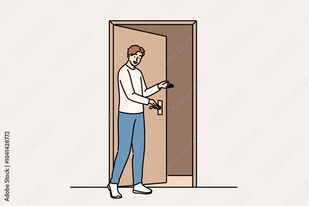 Fototapeta premium Man says welcome standing near door and shows inviting gesture when friends come to visit. Guy demonstrating welcome sign with palm, showing friendly and hospitable character traits