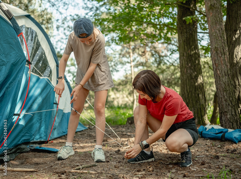 Mother And Daughter Setting Up A Tent In The Forest For The Summer Mother And Daughter Setting Up A Tent In The Forest For The Summer