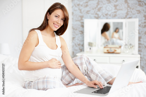 Laptop, motherhood and portrait of pregnant woman for online research, rest and stomach comfort. Smile, baby and future mother with belly, pregnancy and maternity leave to relax in home bedroom