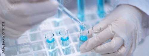 Scientist pipette doppler blue liquid in test tube beaker laboratory science biotechnology biology chemistry medical pharmaceutical DNA medical healthcare research discovery innovation experiment