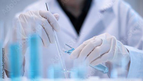 Photos Close-up scientist pouring blue liquid into test tube beaker flask equipment pip