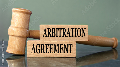 ARBITRATION AGREEMENT - words on wooden blocks with a judge's gavel in the background