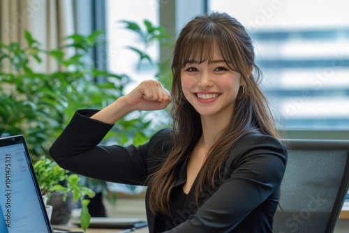 A young Asian businesswoman celebrates her success while working at her laptop in a bright and organized office, represents workplace positivity, motivation. Free Download A young Asian businesswoman celebrates her success while working at her laptop in a bright and organized office, represents workplace positivity, motivation. - GFXLoad